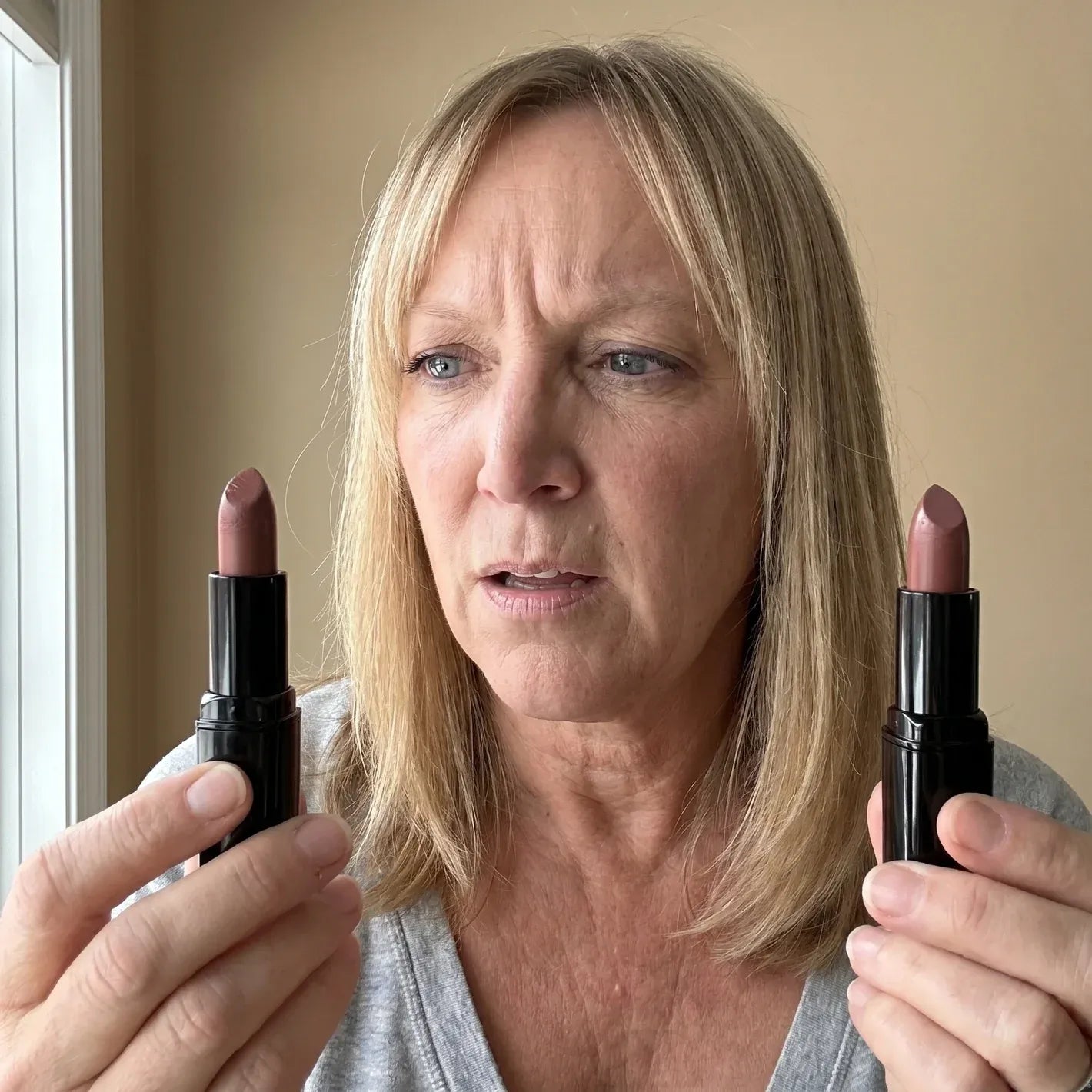 Woman comparing two lipstick shades